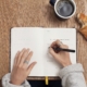 This photo shows someone writing down in a journal and eating to show self care and taking care of themselves during the conveyancing process